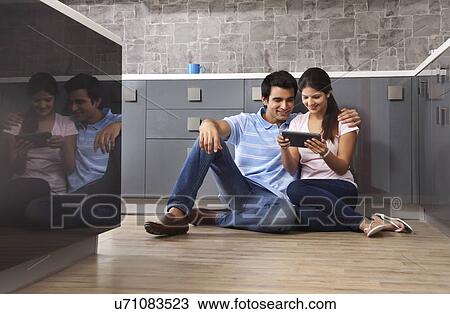 Full length of smiling couple using digital tablet in kitchen View Large Photo Image Stock Image - Full length of smiling couple using digital tablet in kitchen. Fotosearch