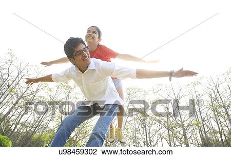 Girl balancing on her fathers back  View Large Photo Image Stock Image - Girl balancing on her fathers back . Fotosearch