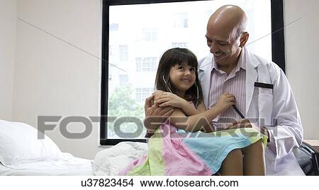 Picture - Girl checking a doctor's heartbeat . Fotosearch