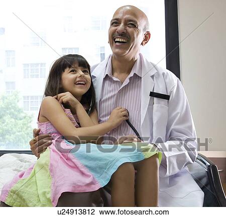 Stock Image - Girl checking a doctor's heartbeat . Fotosearch