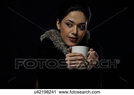 Stock Image - Girl keeping warm with a mug of tea . Fotosearch