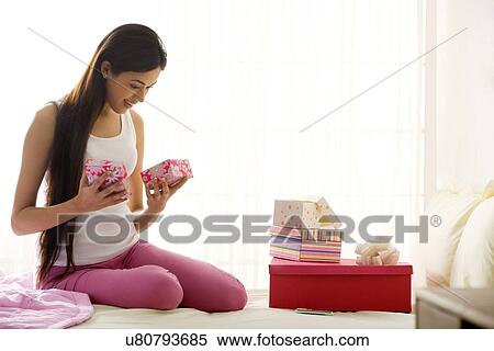 Girl looking at gifts in her hand View Large Photo Image Stock Photography - Girl looking at gifts in her hand . Fotosearch