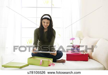 Girl looking at her new computer View Large Photo Image Stock Photograph - Girl looking at her new computer . Fotosearch