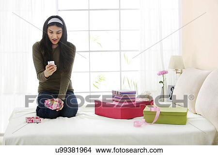Girl looking at her new mobile phone View Large Photo Image Picture - Girl looking at her new mobile phone . Fotosearch
