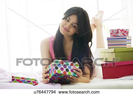 Girl looking at the contents of a gift box View Large Photo Image Picture - Girl looking at the contents of a gift box . Fotosearch
