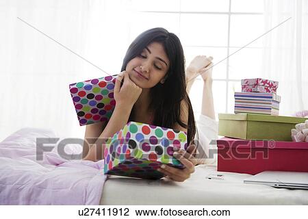 Girl looking at the contents of a gift box View Large Photo Image Stock Image - Girl looking at the contents of a gift box . Fotosearch