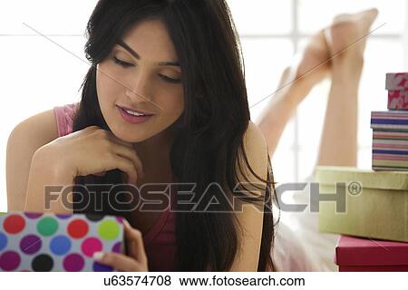 Girl looking at the contents of a gift box View Large Photo Image Stock Photo - Girl looking at the contents of a gift box . Fotosearch