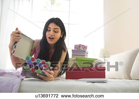 Stock Image - Girl opening a gift box . Fotosearch
