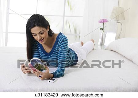 Girl reading a book in bed View Large Photo Image Stock Photo - Girl reading a book in bed . Fotosearch