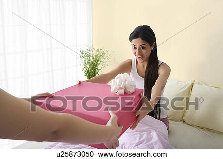 Girl receiving a birthday gift in bed View Large Photo Image Stock Image - Girl receiving a birthday gift in bed . Fotosearch
