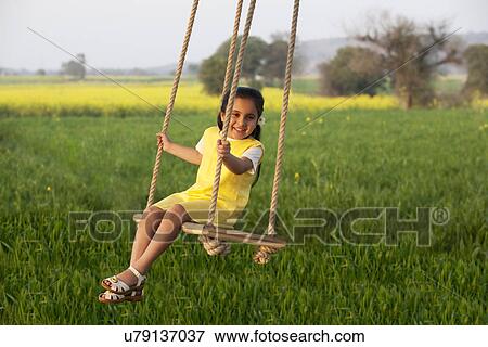 Stock Photo - Girl sitting on a swing . Fotosearch