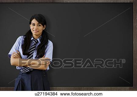 Picture - Girl standing in front of a blackboard . Fotosearch