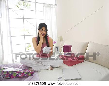 Girl surprised while looking at a gift View Large Photo Image Stock Photography - Girl surprised while looking at a gift . Fotosearch