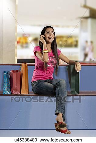 Stock Image - Girl talking on a mobile phone . Fotosearch