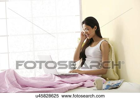 Girl talking on a mobile phone while working View Large Photo Image Stock Photography - Girl talking on a mobile phone while working . Fotosearch