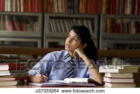 Girl thinking in a school library View Large Photo Image Picture - Girl thinking in a school library . Fotosearch