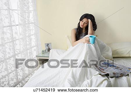 Stock Photo - Girl with a cup of coffee thinking . Fotosearch