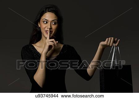 Picture - Girl with a gift bag giving a surprise . Fotosearch