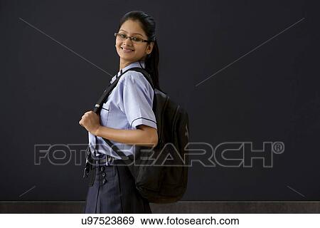 Stock Photo - Girl with a school bag in front of a blackboard . Fotosearch