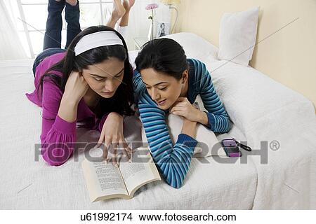 Girls reading a book together View Large Photo Image Picture - Girls reading a book together . Fotosearch