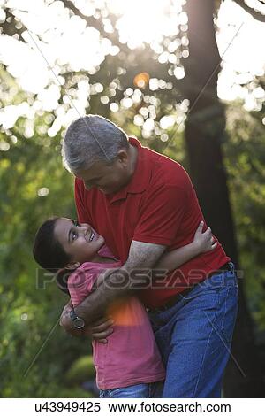 Grandfather and granddaughter hugging in a park View Large Photo Image Stock Photography - Grandfather and granddaughter hugging in a park. Fotosearch