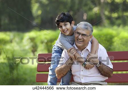 Stock Photograph - Grandfather and grandson enjoying in a park. Fotosearch