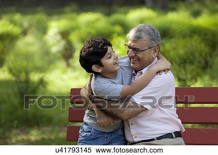 Stock Photography - Grandfather and grandson hugging in a park. Fotosearch