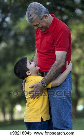 Grandfather and grandson hugging in a park View Large Photo Image Stock Photography - Grandfather and grandson hugging in a park. Fotosearch
