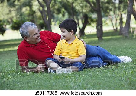 Grandfather and grandson listening to music in a park View Large Photo Image Stock Photography - Grandfather and grandson listening to music in a park. Fotosearch