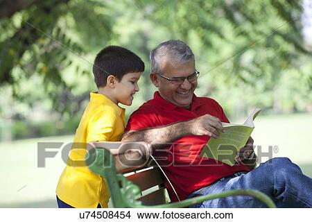 Grandfather and grandson looking a book View Large Photo Image Picture - Grandfather and grandson looking a book. Fotosearch