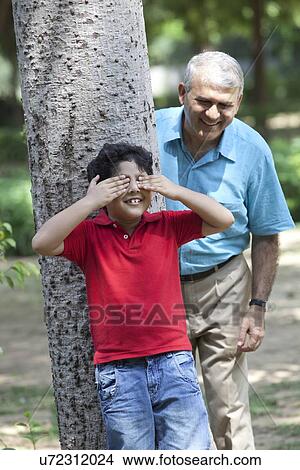 Picture - Grandfather and grandson playing hide and seek. Fotosearch