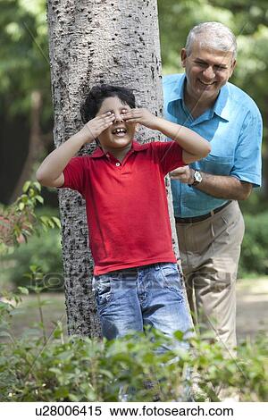 Grandfather and grandson playing hide and seek View Large Photo Image Stock Photography - Grandfather and grandson playing hide and seek. Fotosearch