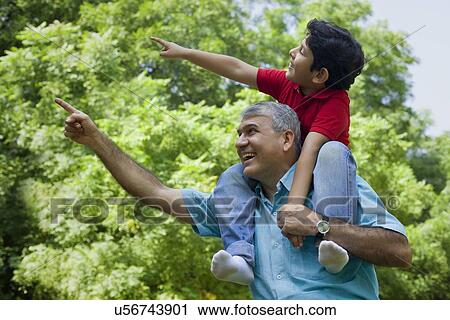 Stock Image - Grandfather and grandson pointing at something. Fotosearch