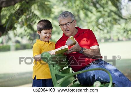 Stock Image - Grandfather and grandson reading a book. Fotosearch