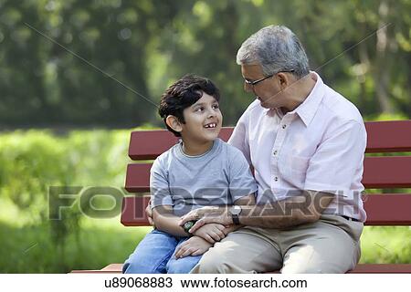 Grandfather and grandson sitting in a park View Large Photo Image Stock Image - Grandfather and grandson sitting in a park. Fotosearch