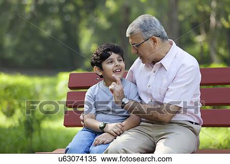 Grandfather and grandson sitting in a park View Large Photo Image Stock Photography - Grandfather and grandson sitting in a park. Fotosearch