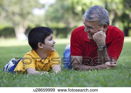 Grandfather and grandson smiling in a park View Large Photo Image Stock Photo - Grandfather and grandson smiling in a park. Fotosearch