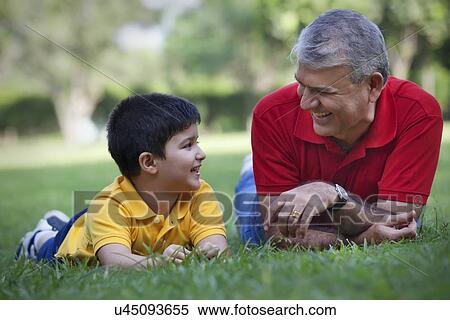 Grandfather and grandson smiling in a park View Large Photo Image Stock Photography - Grandfather and grandson smiling in a park. Fotosearch