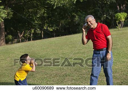 Stock Photo - Grandfather and grandson talking through paper cups. Fotosearch
