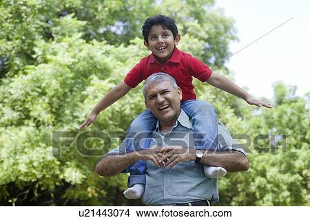 Picture - Grandfather carrying his grandson on his shoulders. Fotosearch