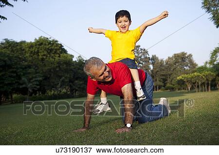 Stock Photo - Grandfather giving his grandson a piggyback ride. Fotosearch