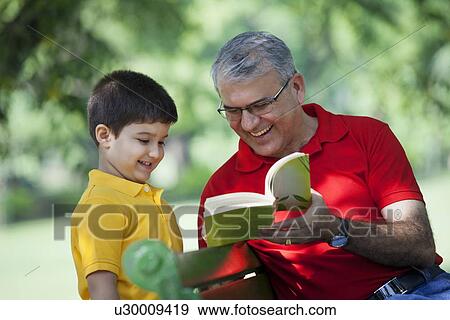 Stock Photo - Grandfather showing book to grandson. Fotosearch