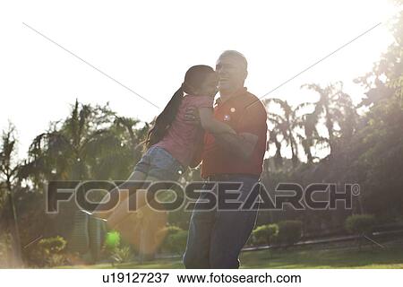 Grandfather swinging his granddaughter View Large Photo Image Stock Photo - Grandfather swinging his granddaughter. Fotosearch