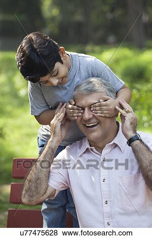 Grandson covering grandfathers eyes View Large Photo Image Stock Photo - Grandson covering grandfathers eyes. Fotosearch