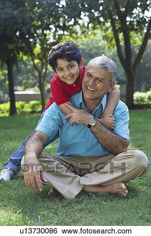 Grandson hugging grandfather in park View Large Photo Image Stock Photograph - Grandson hugging grandfather in park. Fotosearch