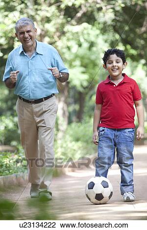 Grandson playing soccer as grandfather watches on View Large Photo Image Stock Image - Grandson playing soccer as grandfather watches on. Fotosearch