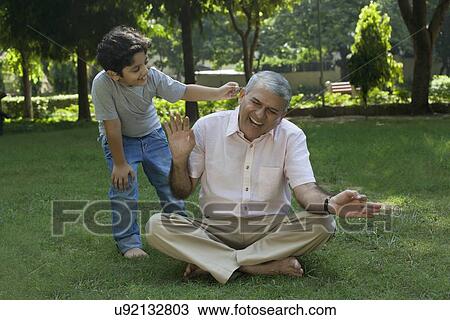 Grandson tickling grandfather in ear View Large Photo Image Stock Image - Grandson tickling grandfather in ear. Fotosearch
