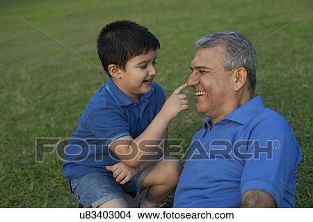 Picture - Grandson touching his grandfathers nose. Fotosearch