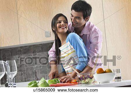 Happy couple cutting vegetables together in kitchen View Large Photo Image Stock Photo - Happy couple cutting vegetables together in kitchen. Fotosearch