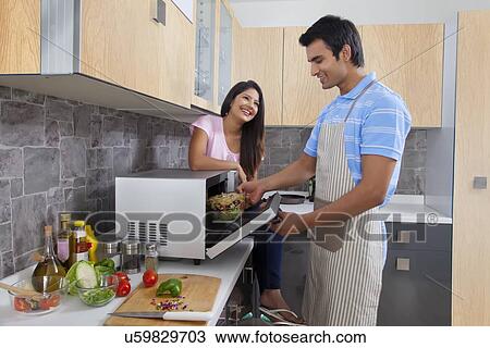 Happy couple preparing meal in kitchen View Large Photo Image Stock Image - Happy couple preparing meal in kitchen. Fotosearch